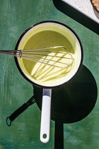 Calamansi Curd in a sauce pan with a whisk.