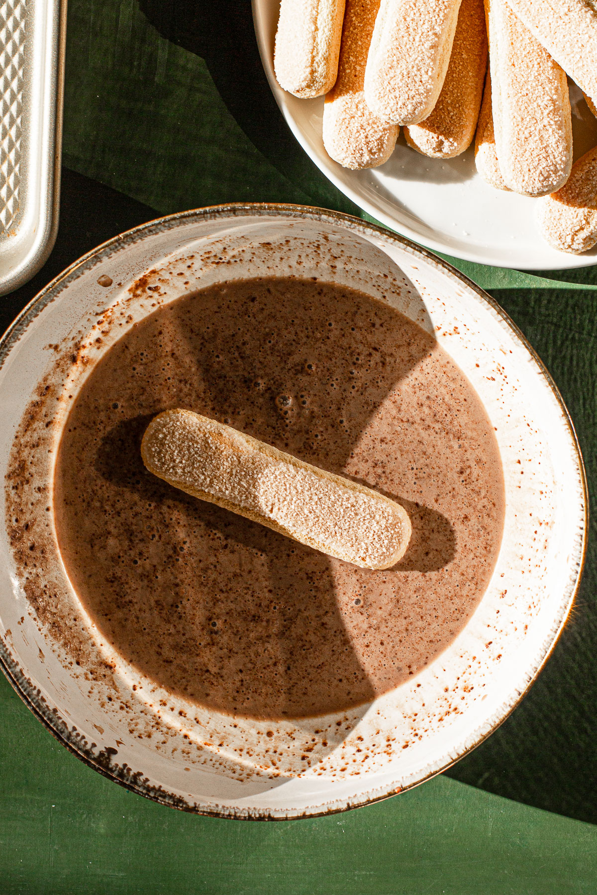 Dipping the lady finger in milo and milk bowl.