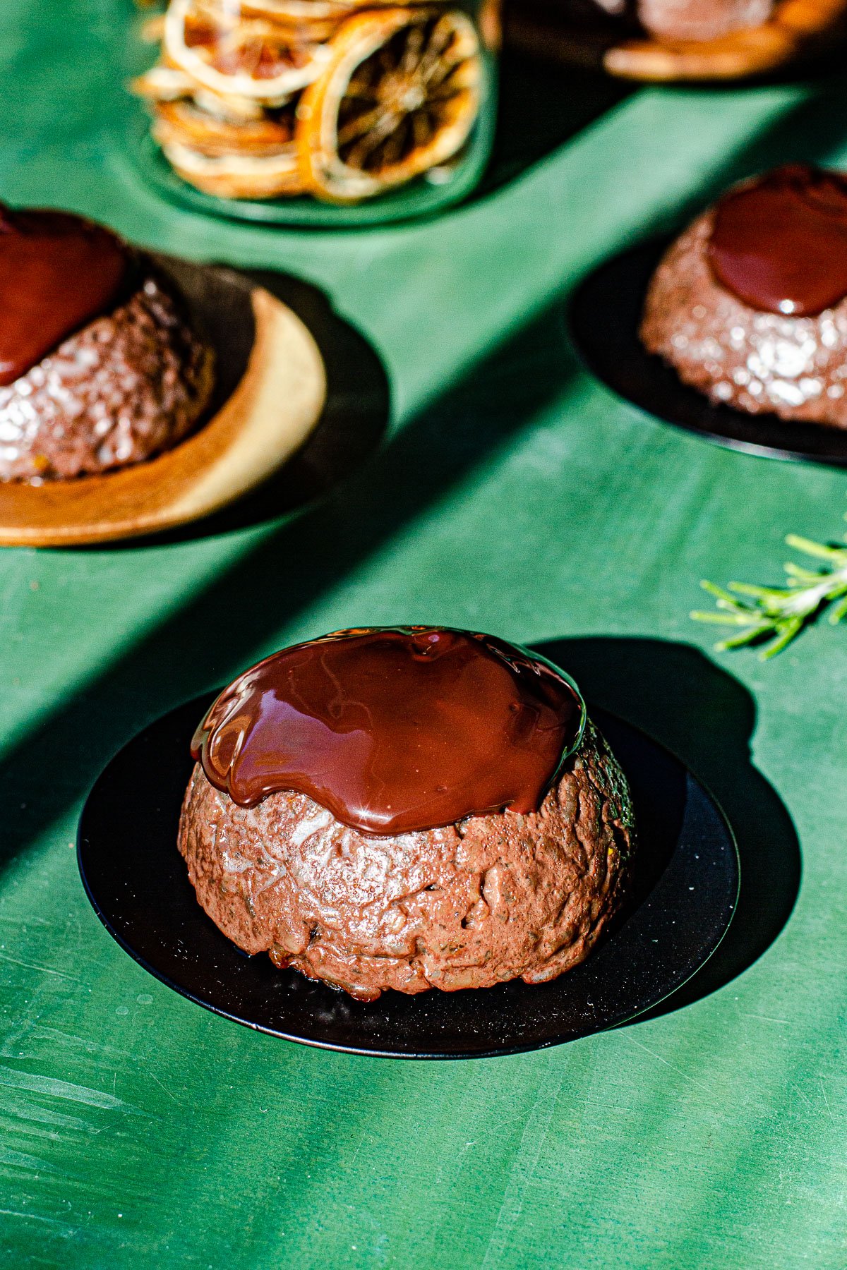 Biko covered in chocolate sauce on a orange backdrop.
