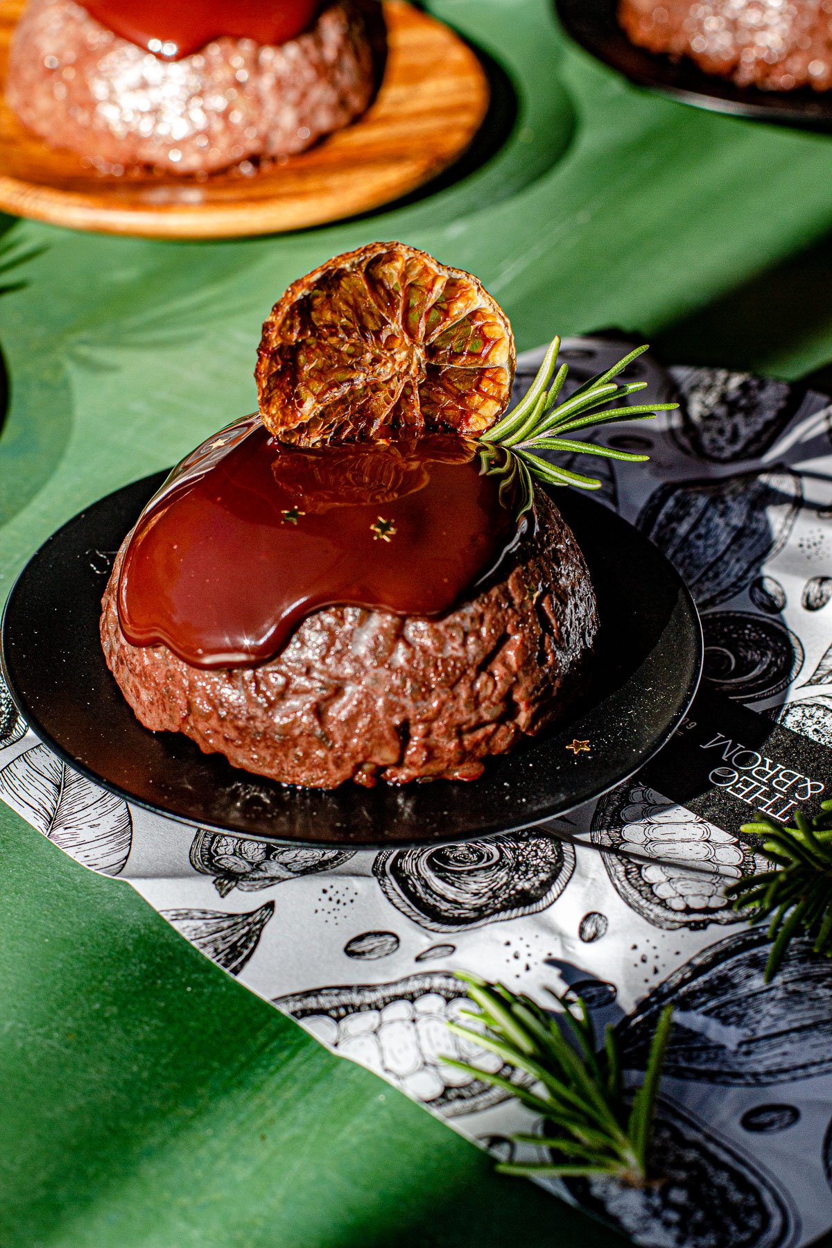 Orange Chocolate Biko on a black platter on a chocolate wrapper.