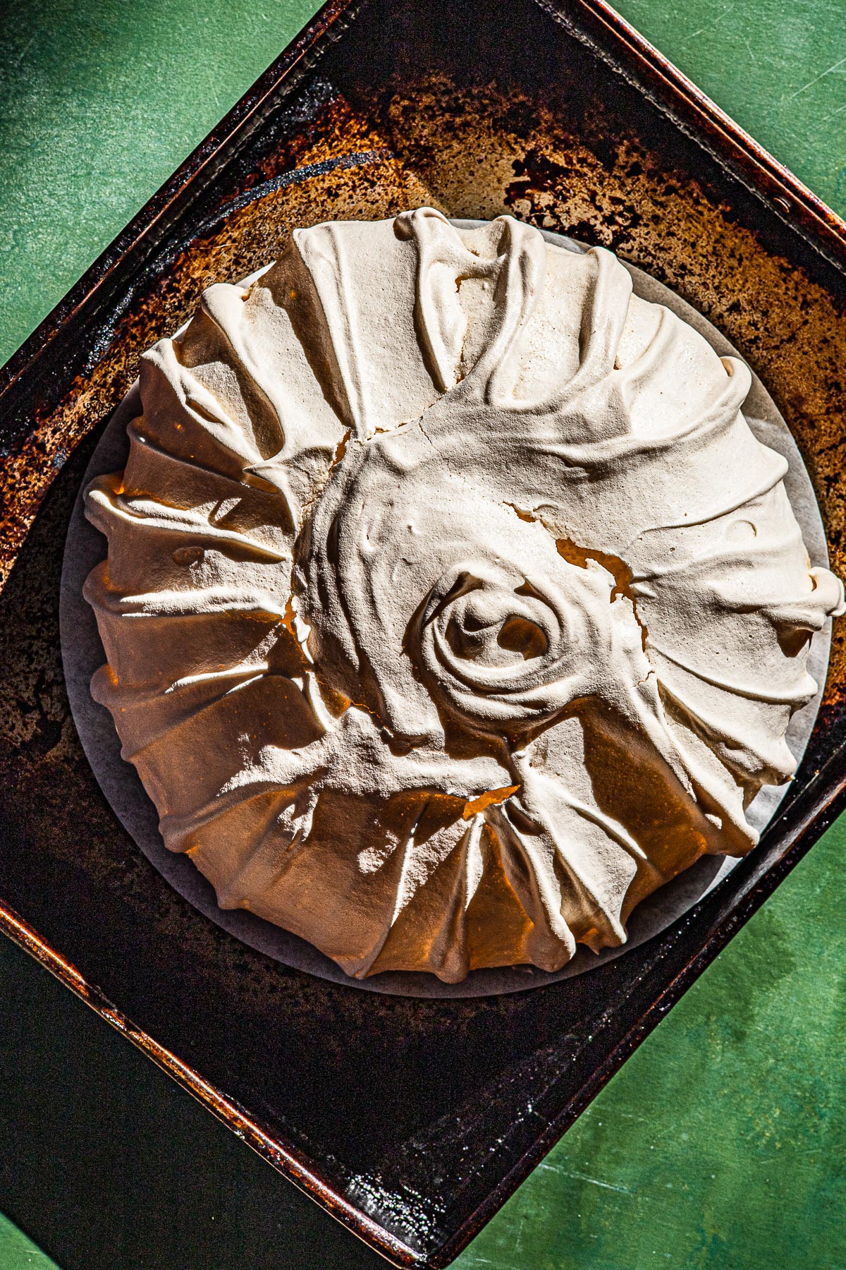Just baked pavlova shell on a baking sheet.