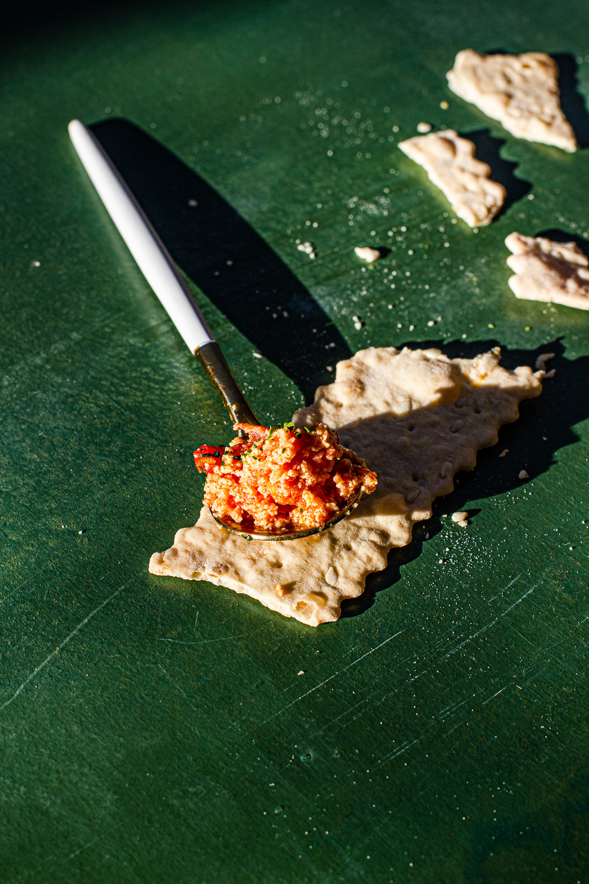 Ginisang Kamatis on a spoon on top of a cracker.