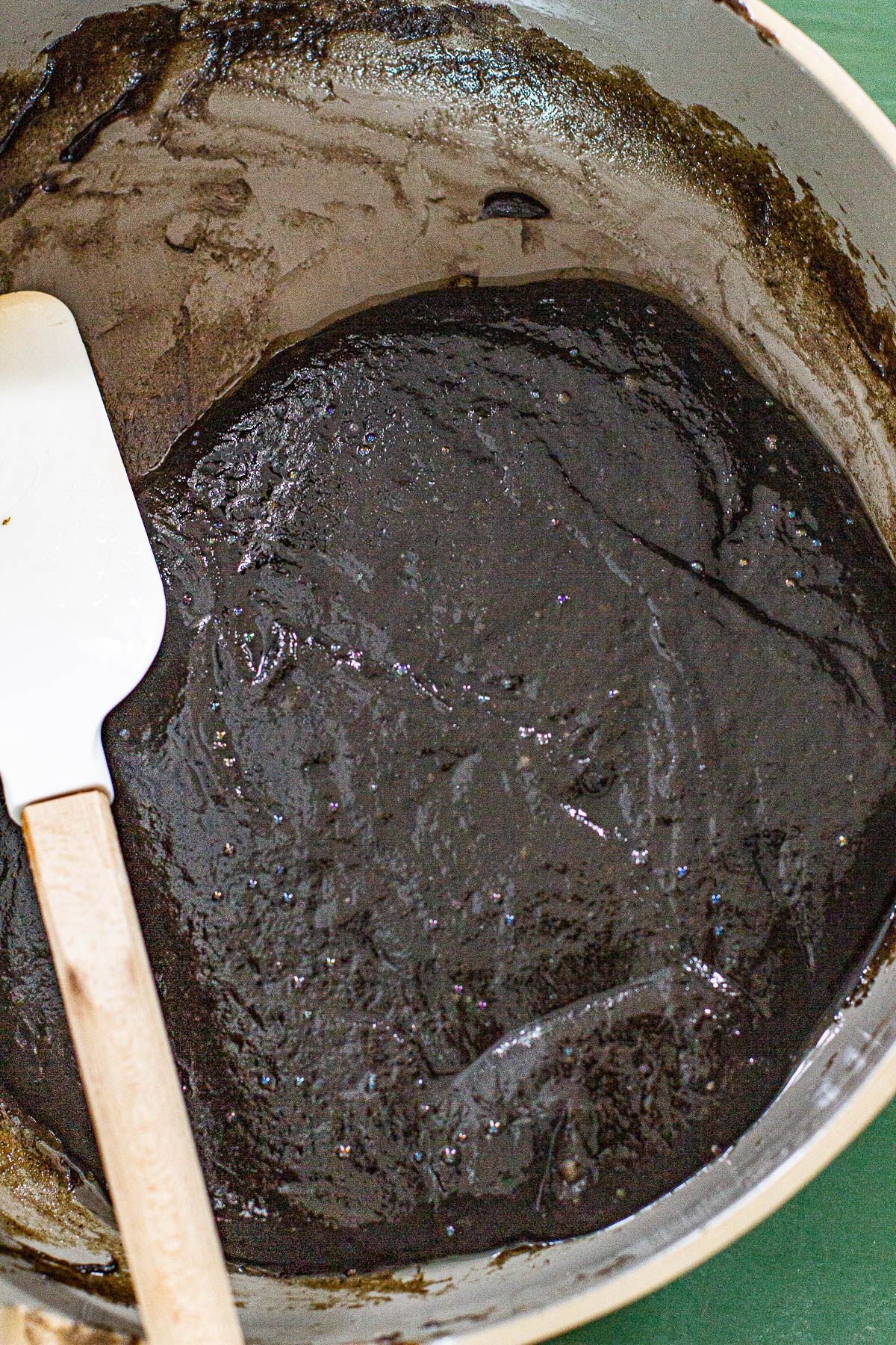 Cooked black sesame kalamay in a non stick pan with spatula.