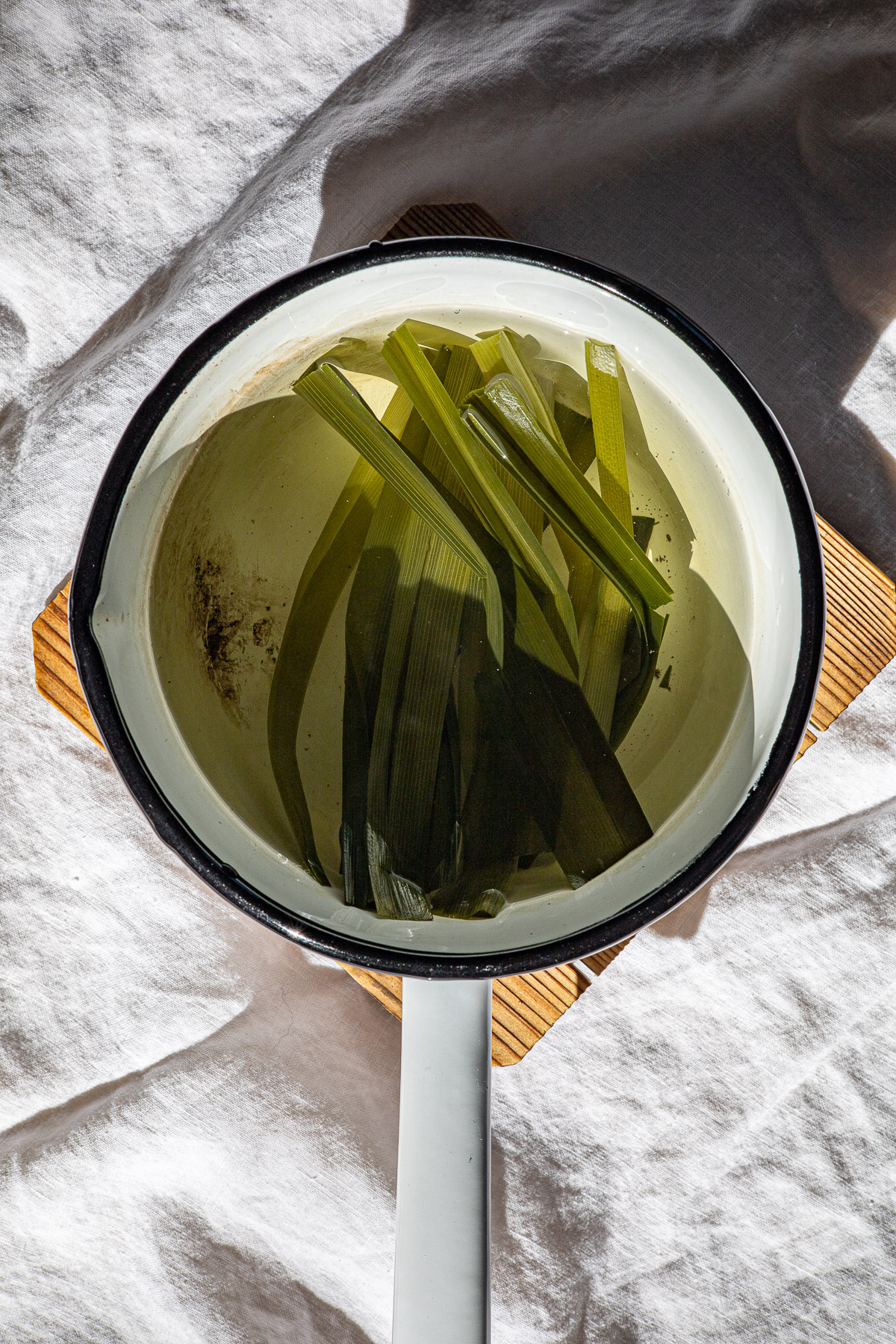 Pandan leaves in water in a sauce pan.  
