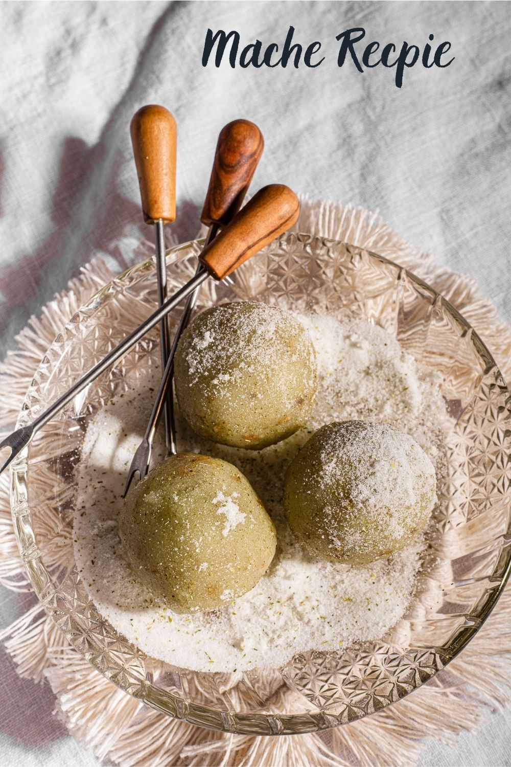 3 Balls of Mache (Buko Pandan Mochi Balls) on a glass plate with mini tongs on top of a macrame coaster.