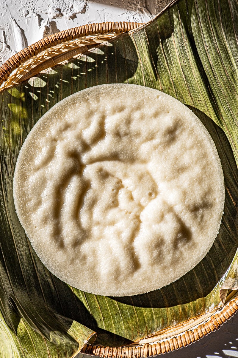 Puto Biñan on a banana leaf and rattan tray.