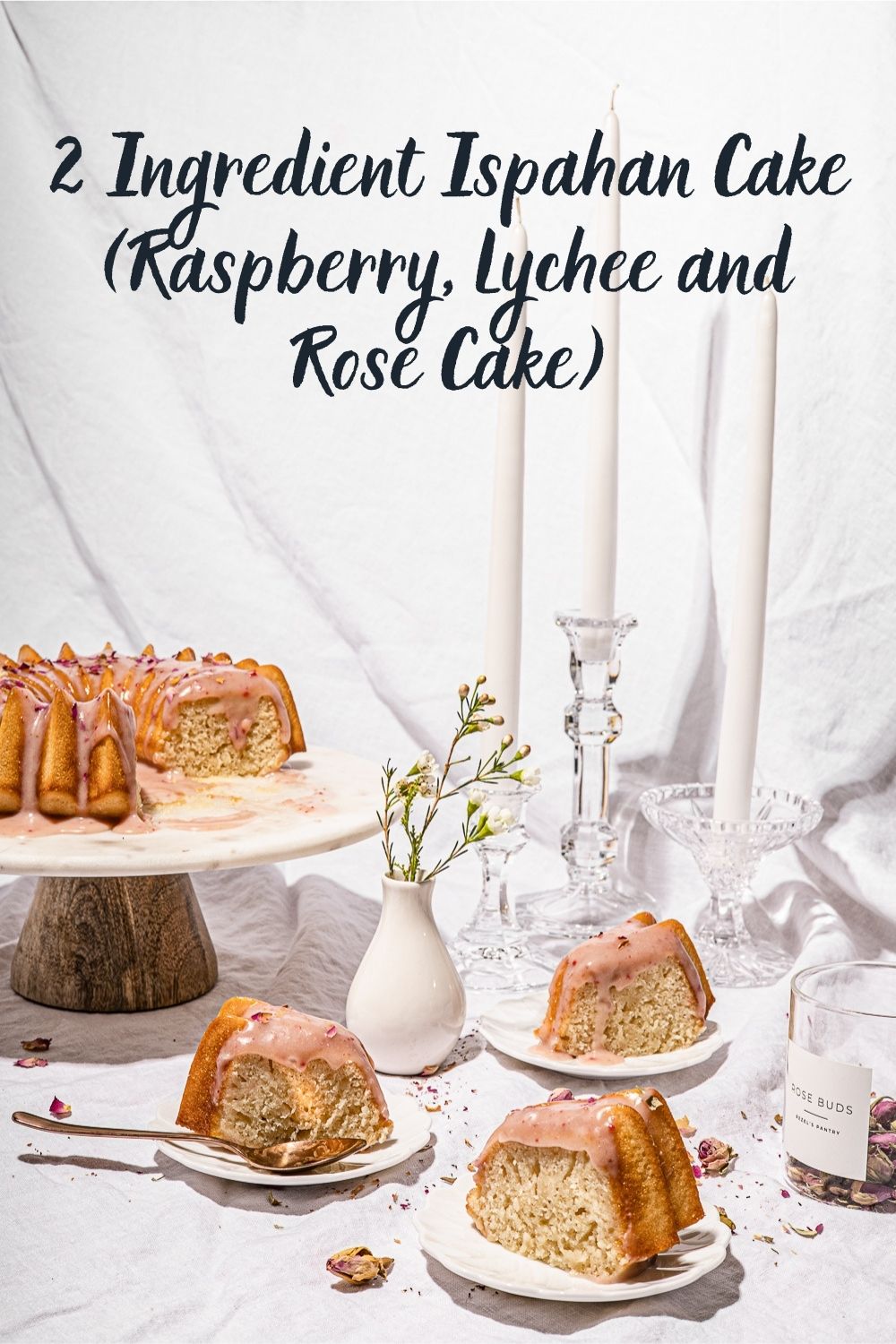 Ispahan Cake slices on small plates with candle sticks in the background.