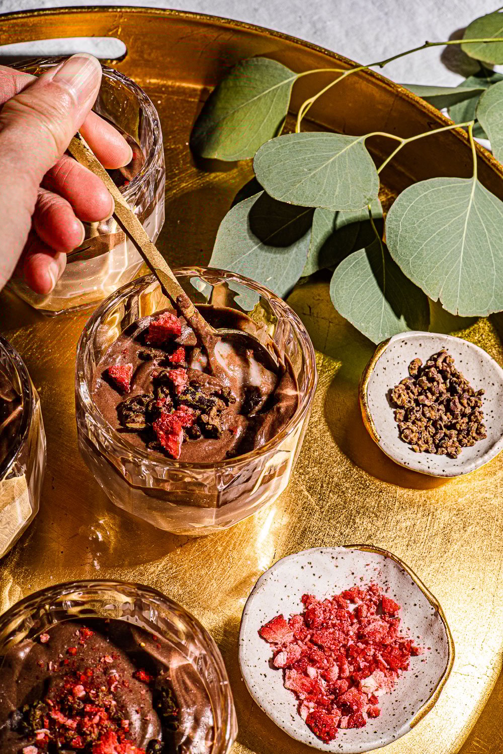 Tibok Tibok Recipe with Chocolate and Strawberry Layers in a glass being scooped with a gold spoon.