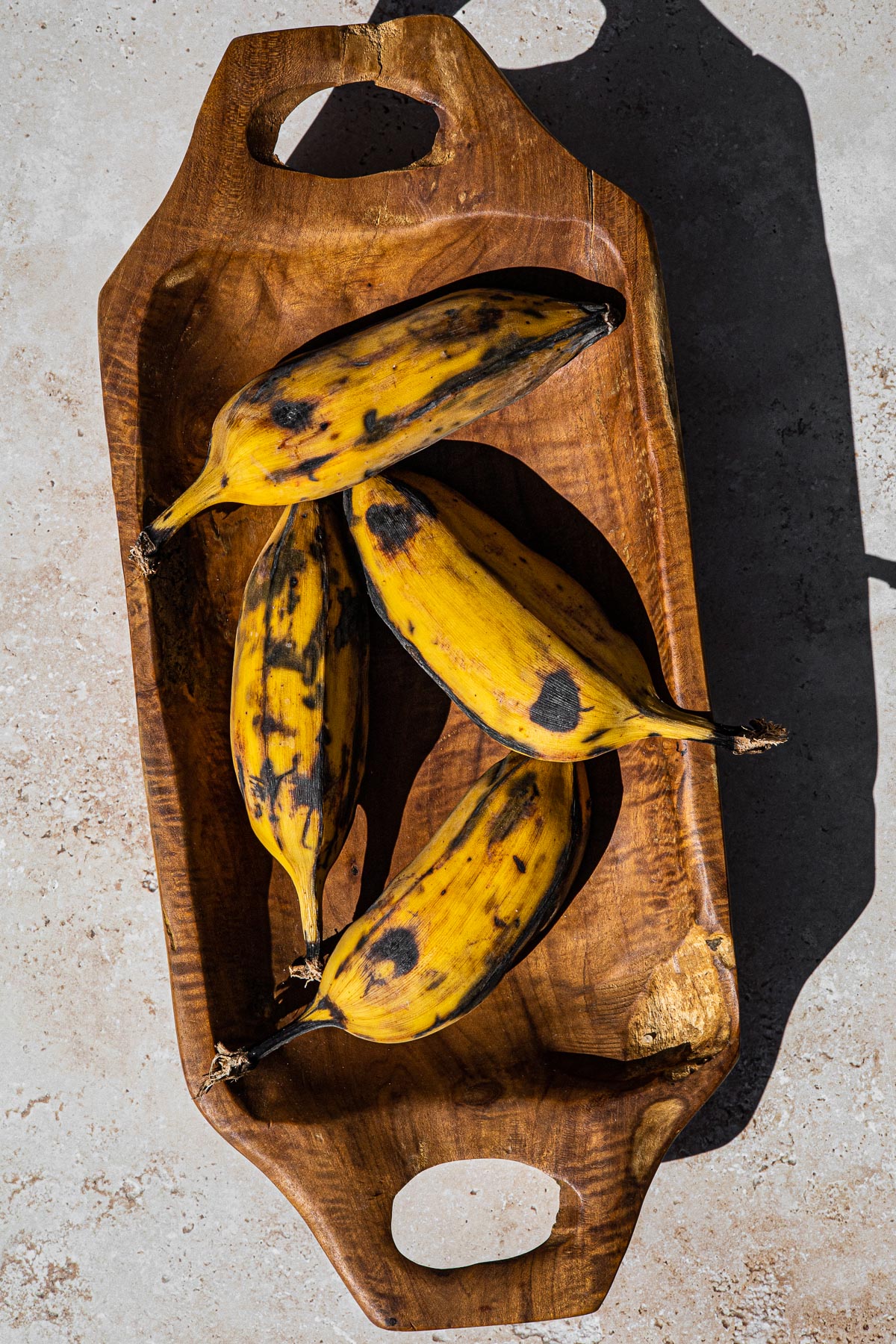 4 Saba Bananas on a long wooden bowl.