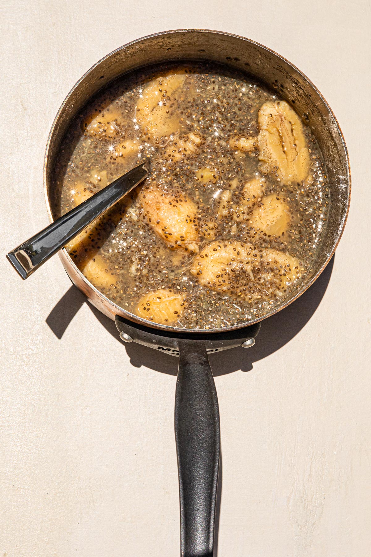 Saba and Chia in a sauce pan with a silver spoon.