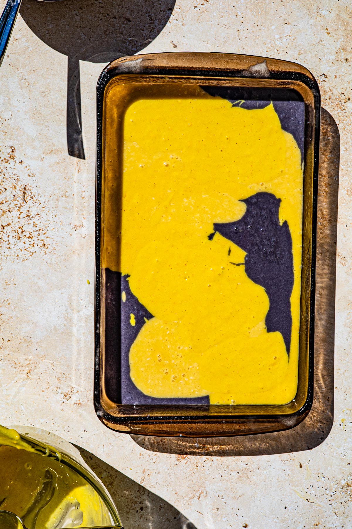 Raw cake batter in a glass baking dish.
