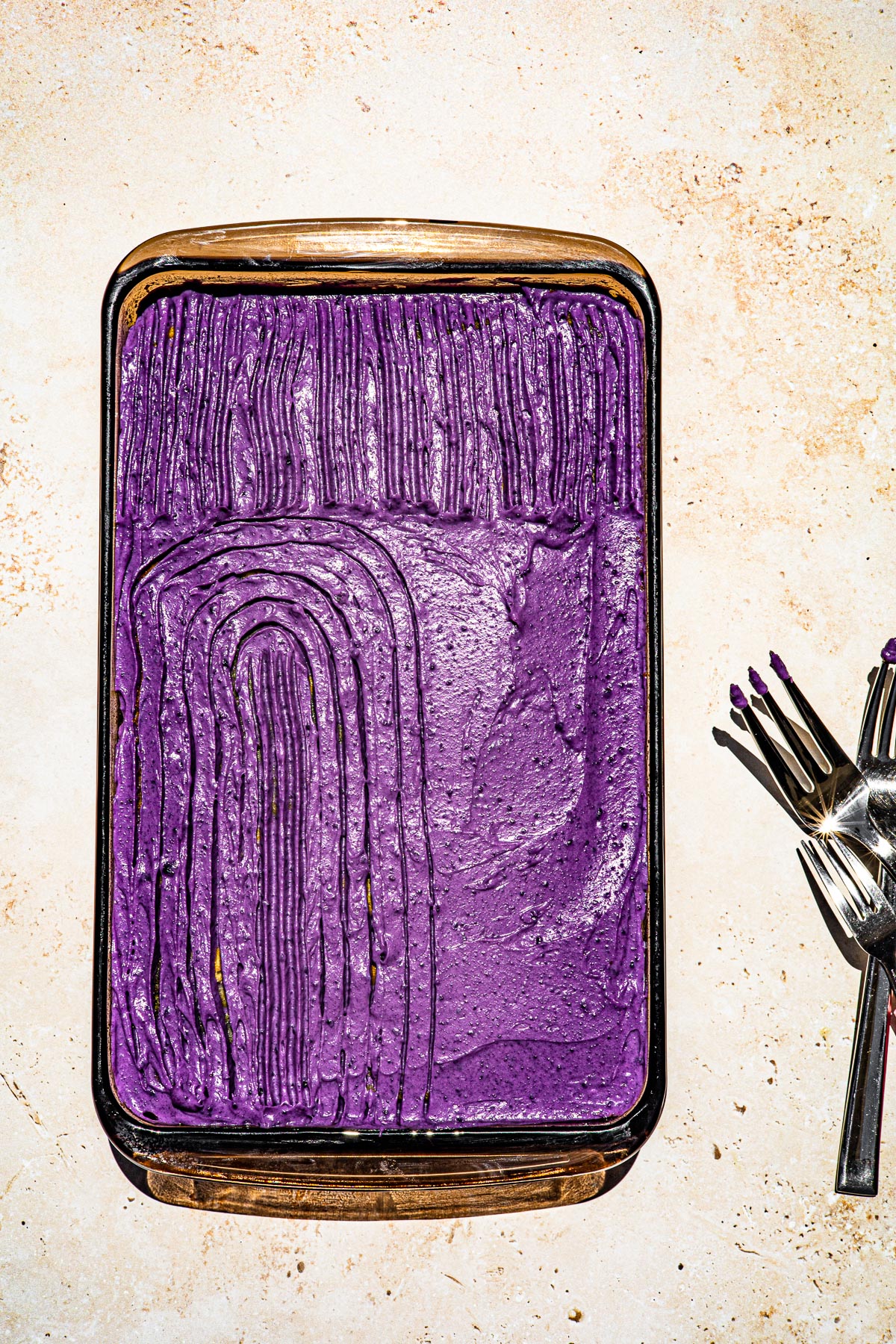 Ube Sheet Cake half decorated with forks.