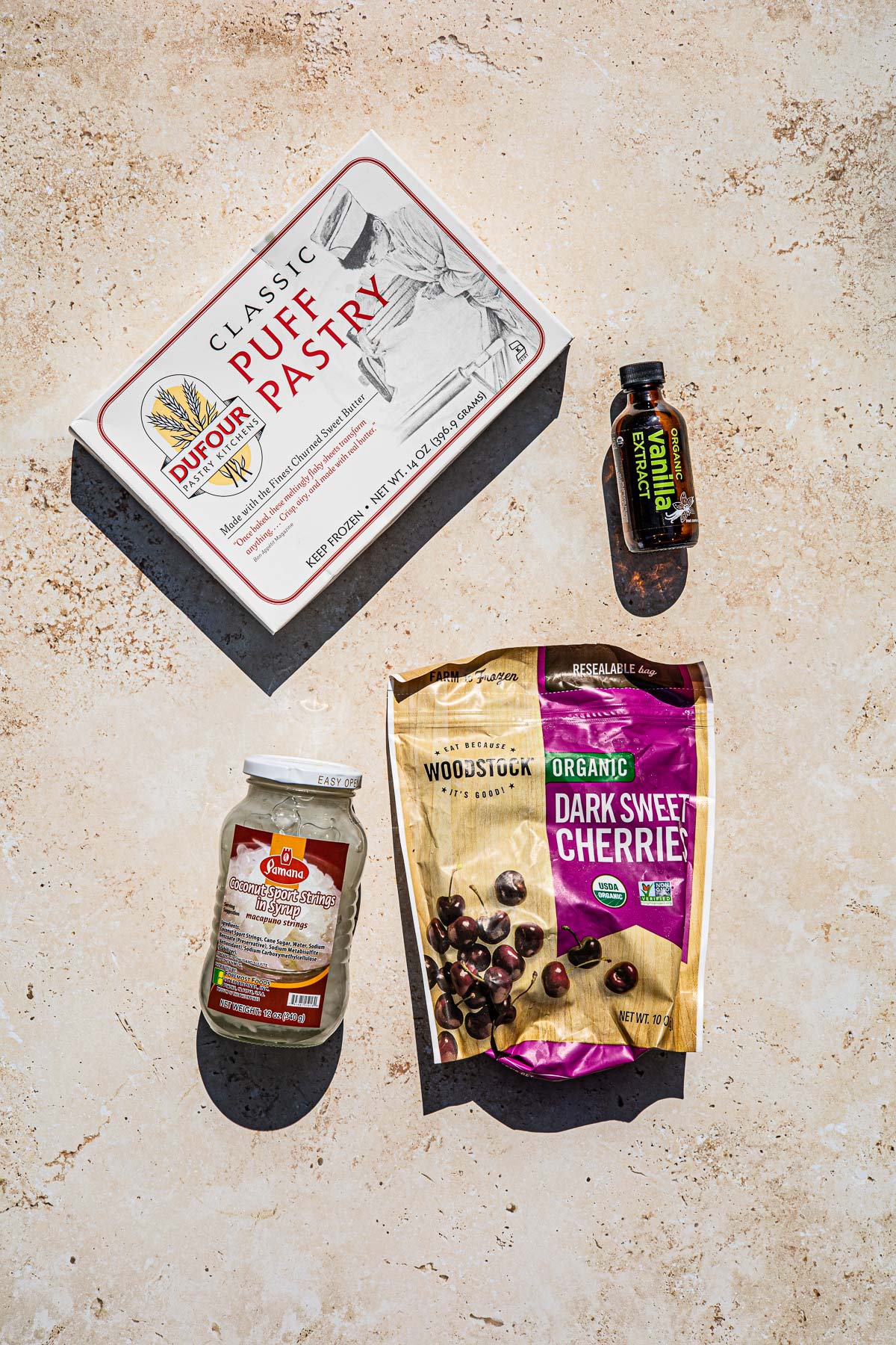Puff Pastry in a box, bottle of vanilla extract, Jar of Macapuno strings, bag of frozen cherries.