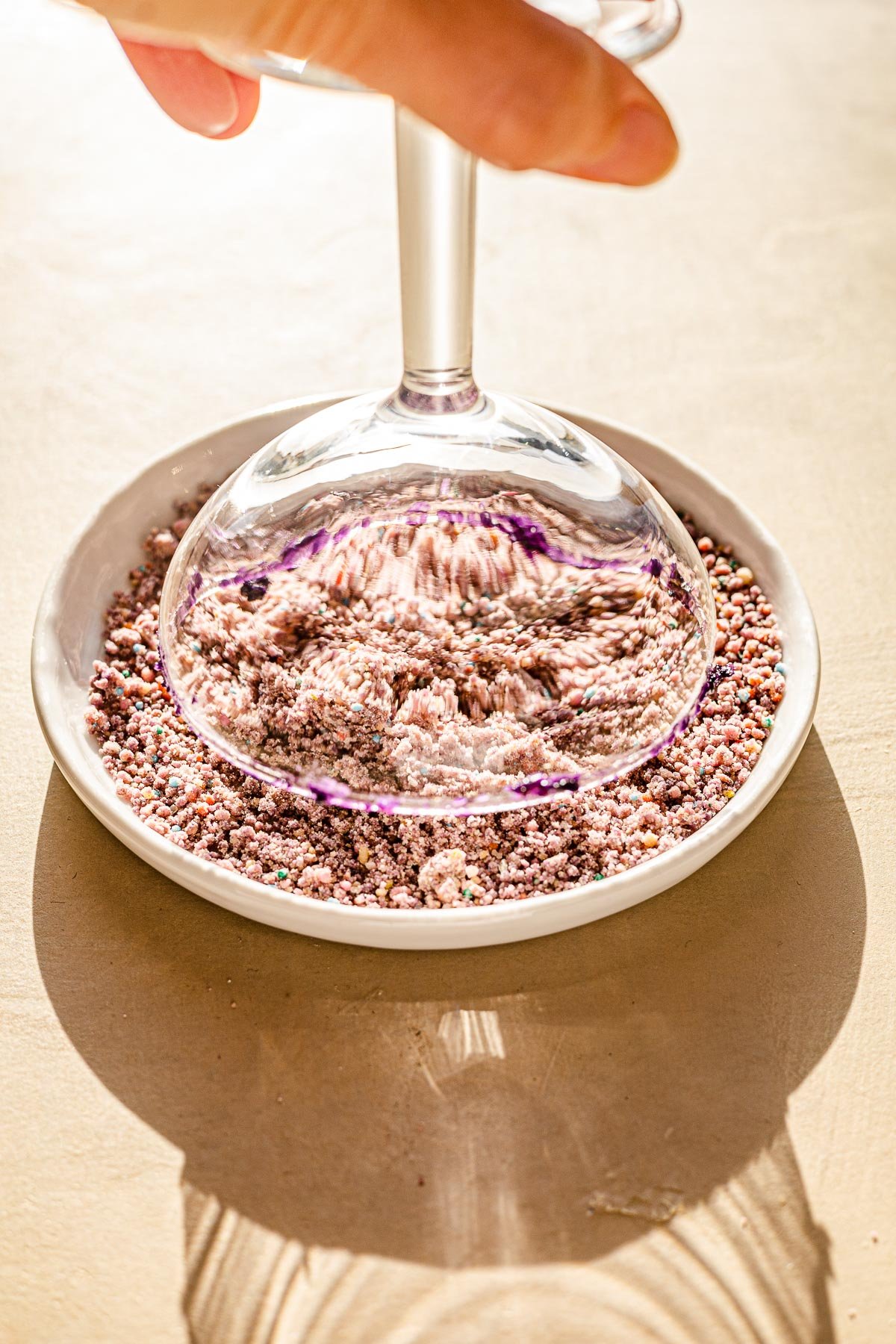 Cocktail glass being dipped in polvoron.