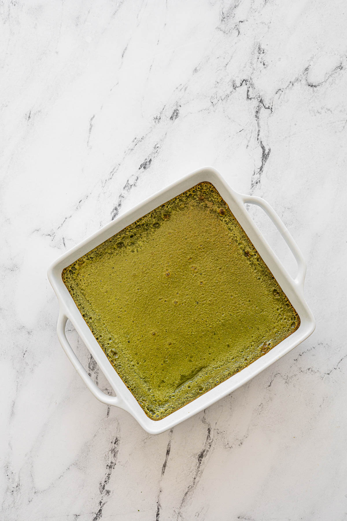 Baked Matcha Biko in white baking dish.