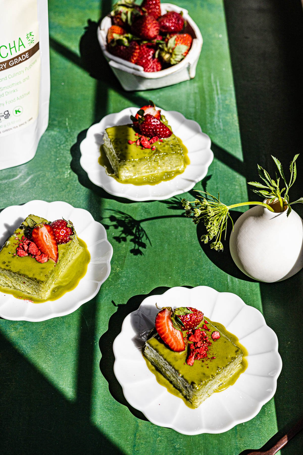 Matcha Biko served on plates on a green background.