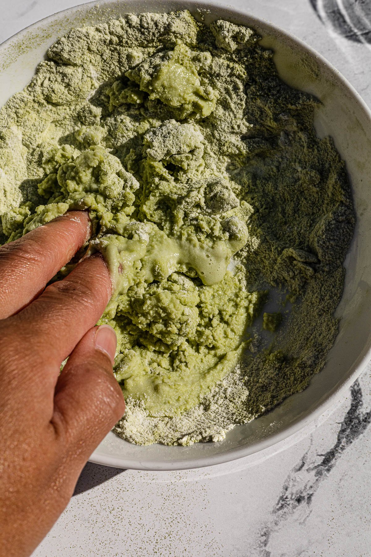Mixing together Pilipit sa Malagkit dough with fingers.
