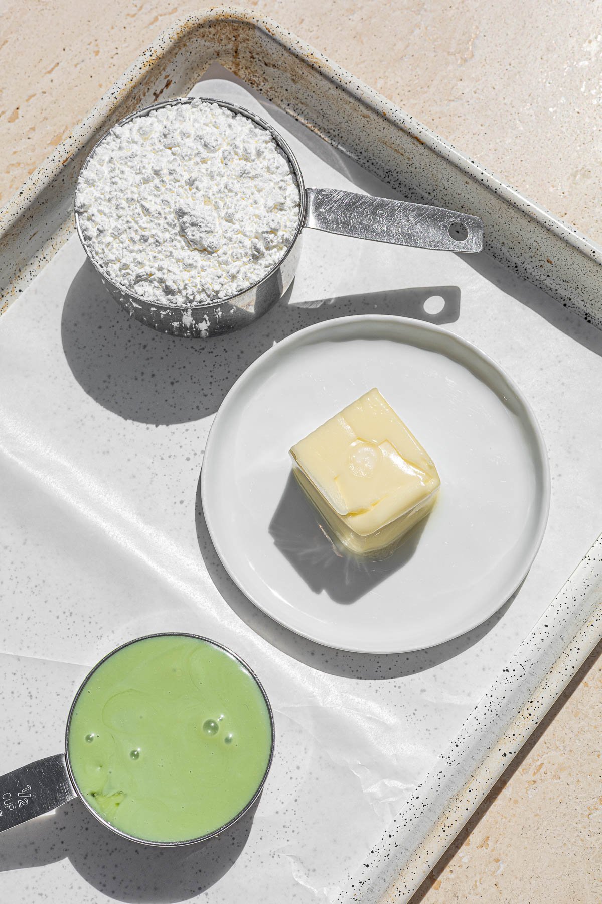 Corn starch, butter and pandan condensed milk on a tray.