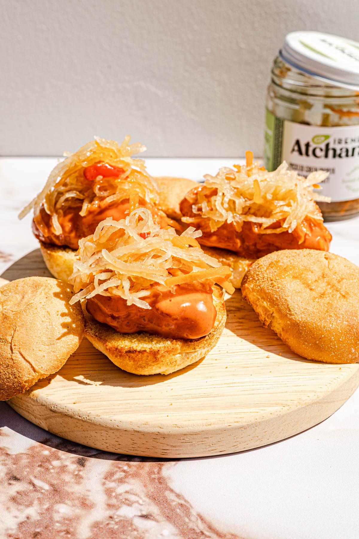 Escabeche Fish sliders with atchara on a wooden serving board.