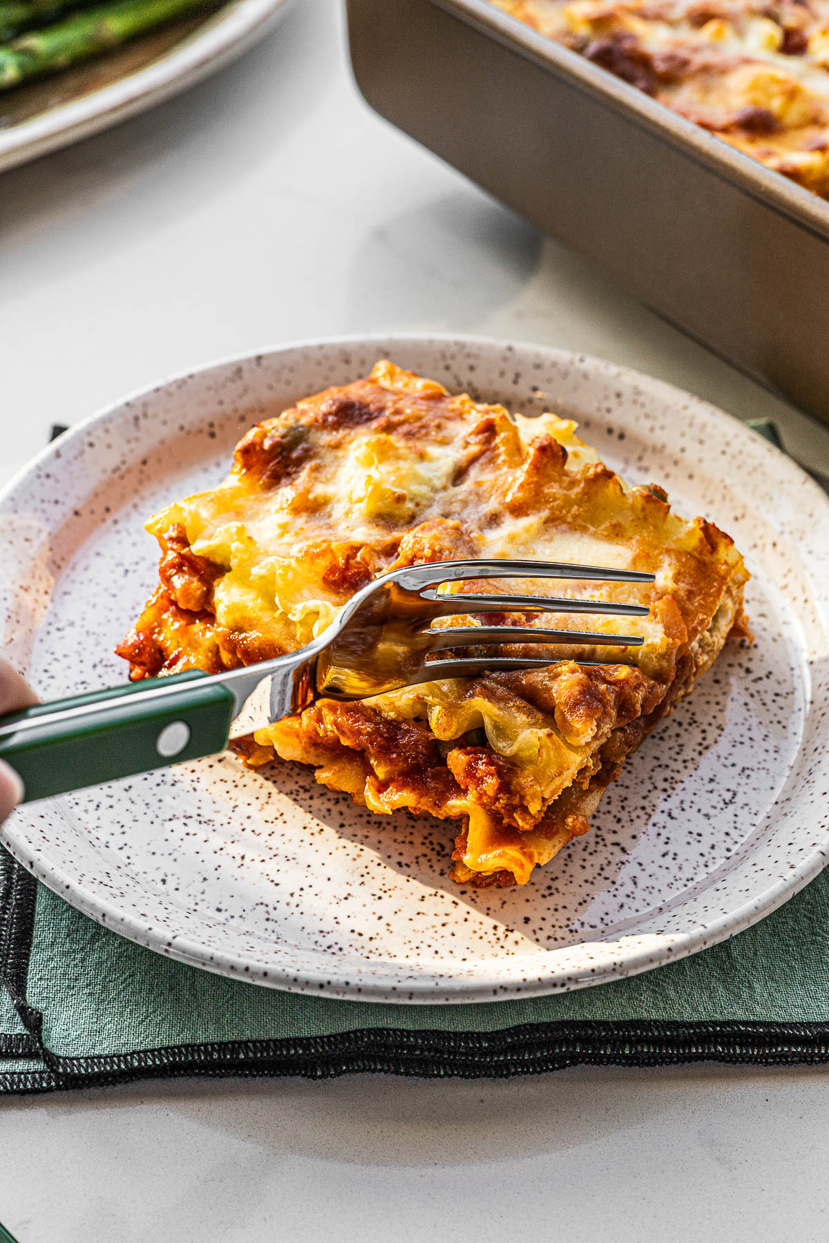Afritada Lasagna being cut with a fork.