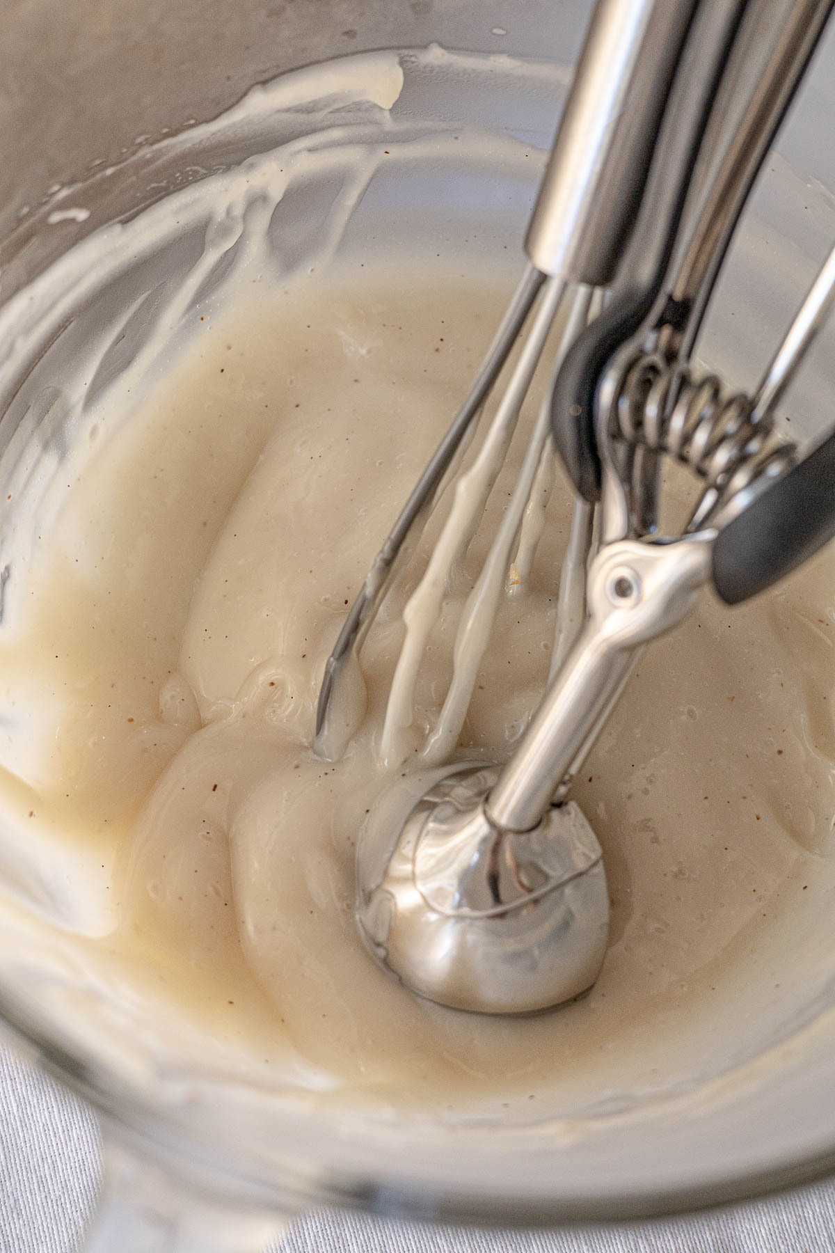 Maja Blanca Pudding / Pastry Cream in a bowl with a whisk and scooper.