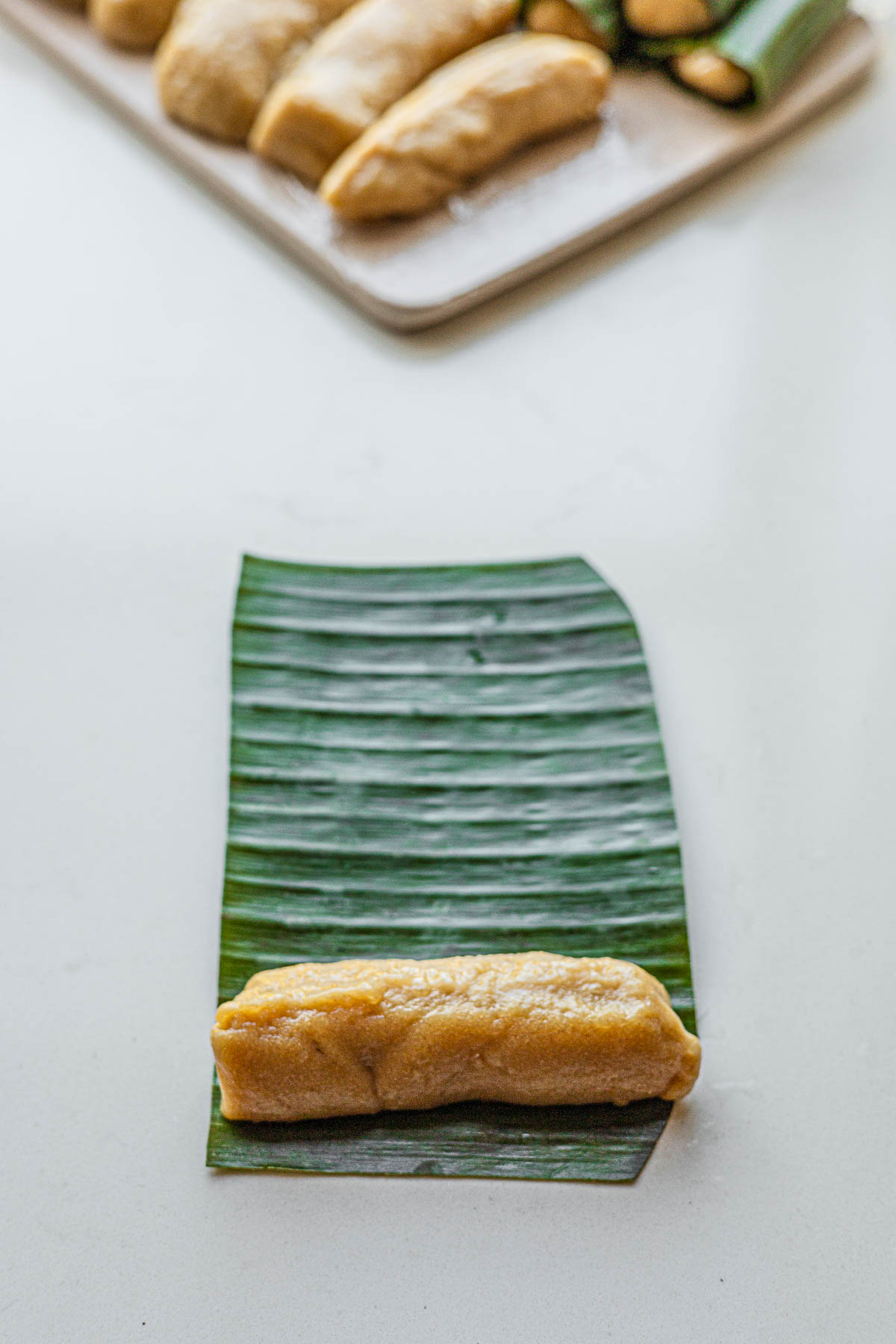 Rolling Baye Baye in a banana leaf.