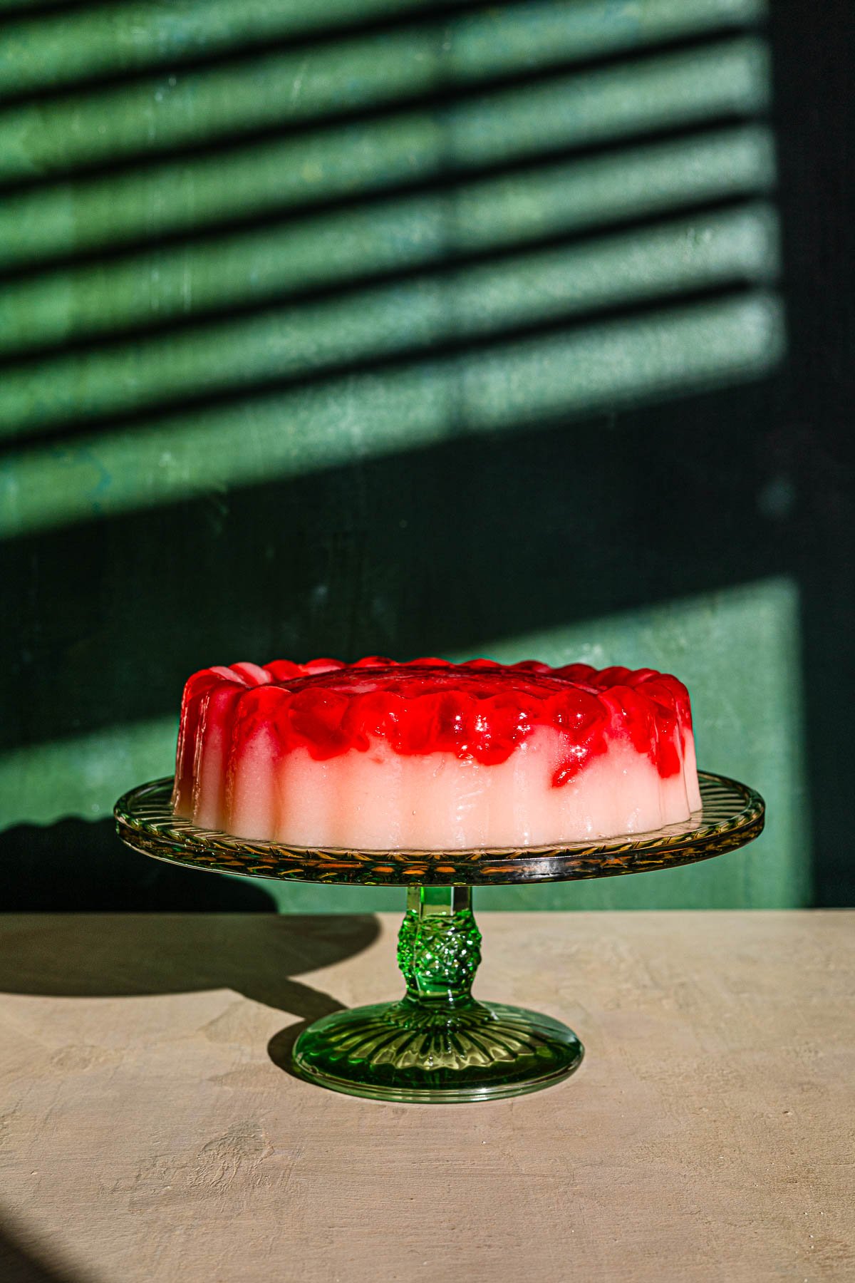 Broken Glass with Lychee, Yakult and strawberry on a green serving stand.